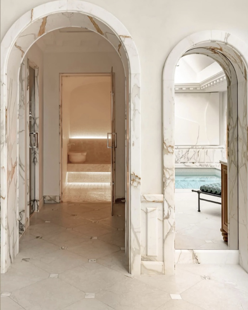 Enfilade d'arches de marbre ouvrant sur un bassin