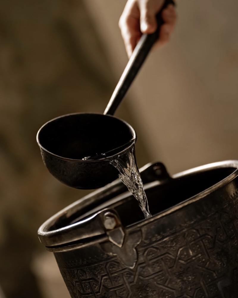 Filet d'eau versé d'une casserole d'argent ciselée