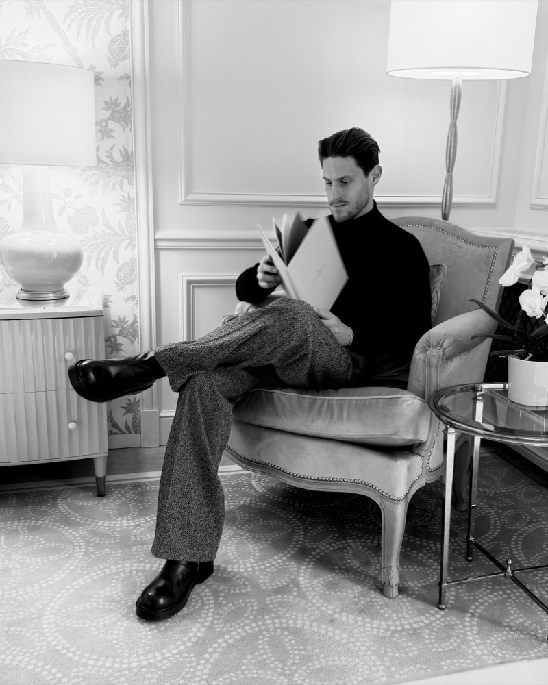 Salon lambrissé en noir et blanc, lecture dans une bergère