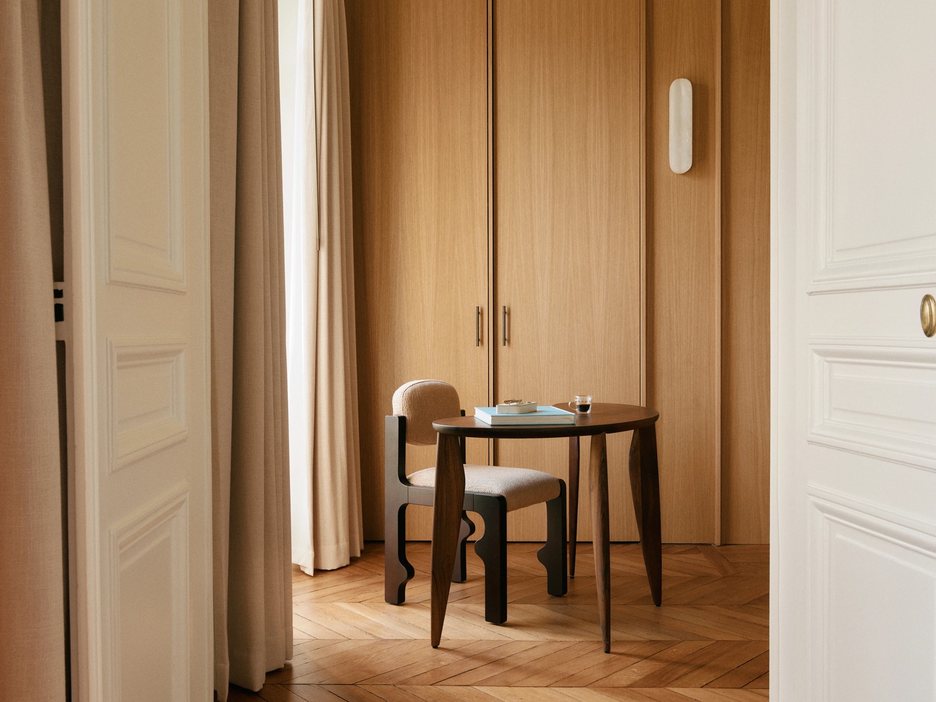 Chambre claire, bureau de bois et porte entrouverte